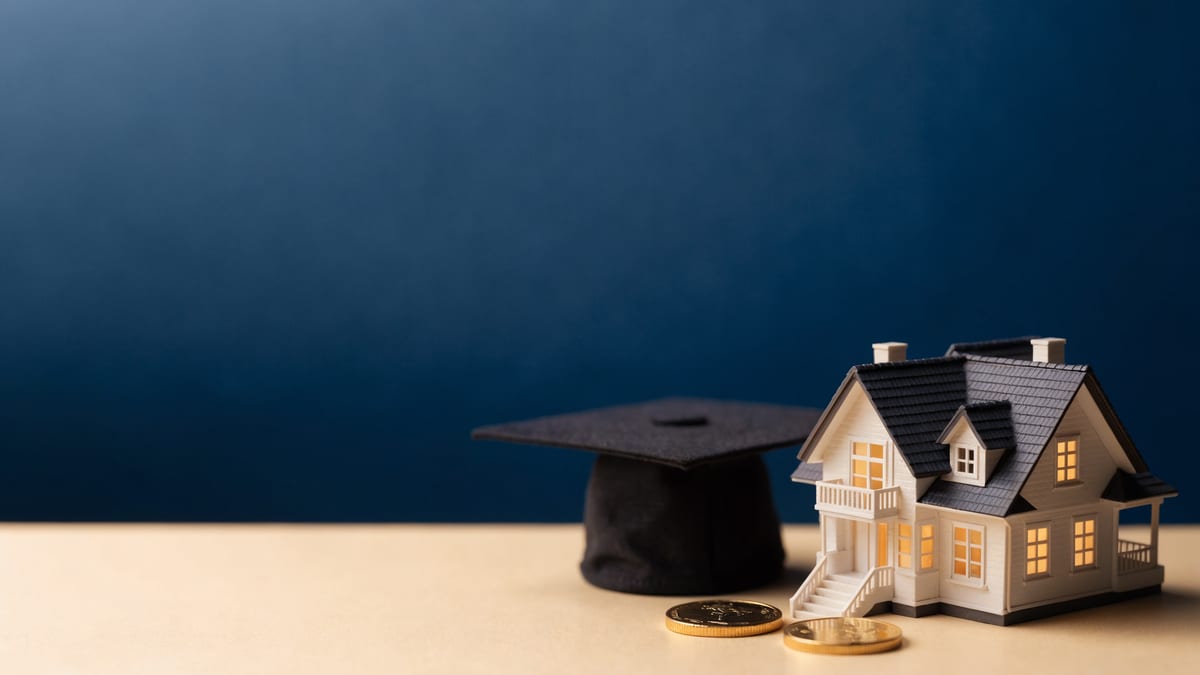 Scale model house on a navy backdrop with a graduation cap beside it, representing study debt and borrowing power